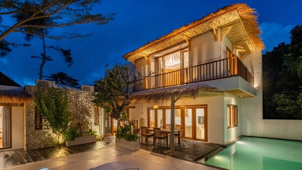 A two-story house with a pool, outdoor seating, and a thatched roof. - Peaceful 3BR Villa Located in Pecatu - 10 Min to the Beach (Pecatu)