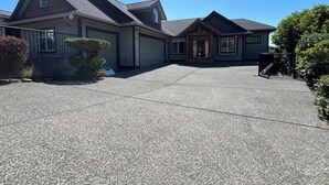 A two-story house with a covered porch, a garage, and a driveway.