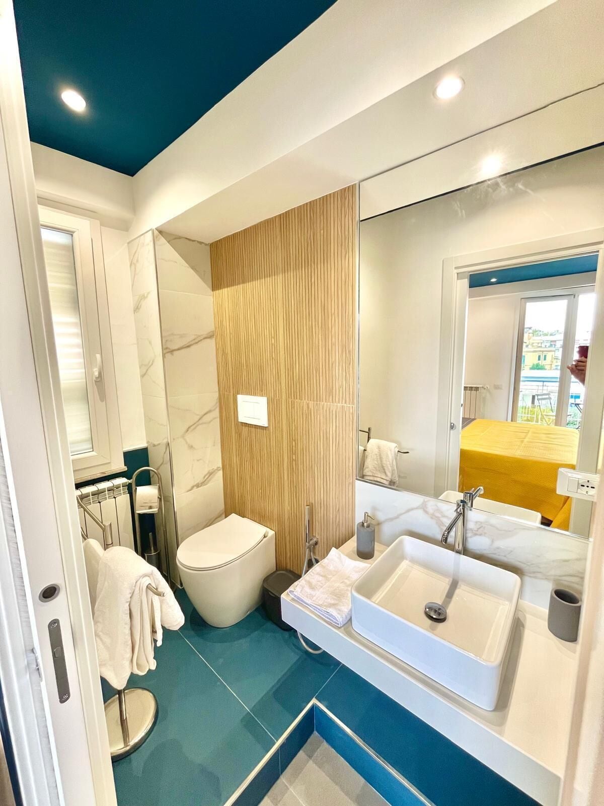 Une salle de bain moderne avec des toilettes, un lavabo et un miroir.