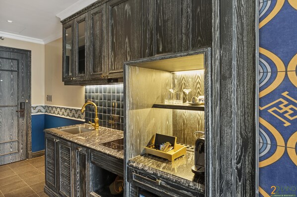 A kitchen with dark wooden cabinets, a marble countertop, and a large mirror. - 22Land Heritage Hotel & Retreat (Hanoi)