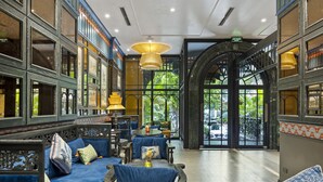 Un hall d’entrée spacieux, aménagé dans un style traditionnel, avec un espace salon central et de grandes fenêtres donnant sur l’extérieur.
