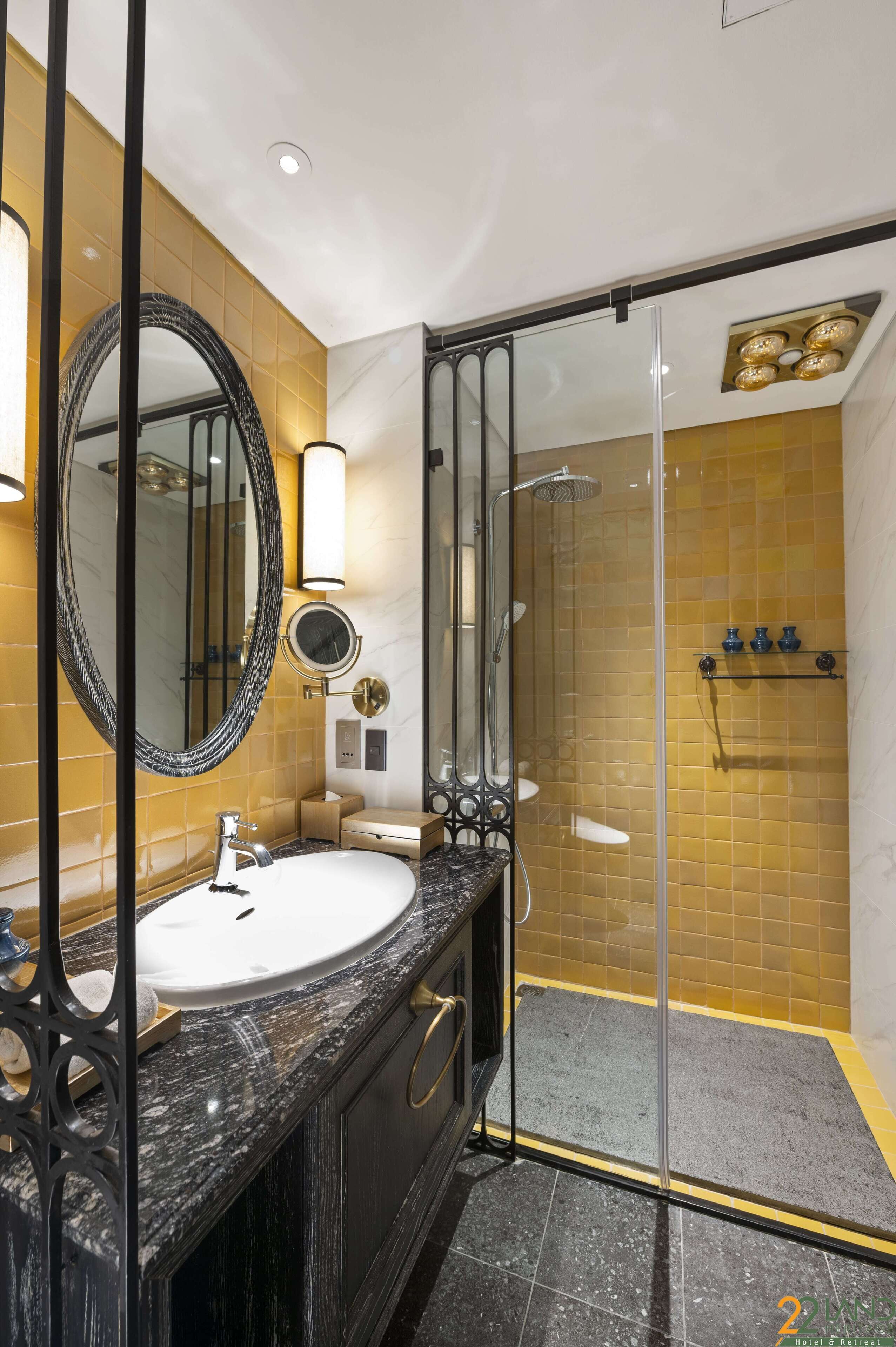 A modern bathroom with a marble sink, a large mirror, and a glass-enclosed shower area.