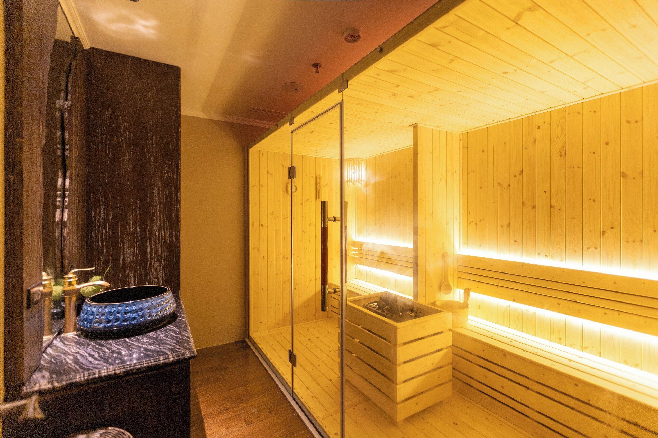 Una sauna con pareti in legno e una porta in vetro.