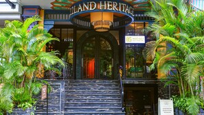 L’entrée d’un hôtel, avec une enseigne indiquant : « 22LAND HERITAGE ».