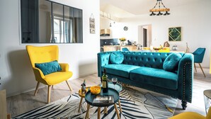 A modern living room with a yellow armchair, a teal sofa, and a coffee table. - An enchanting townhouse, a unique experience! (Nozay)