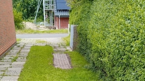 Un césped bien cuidado con un sendero de ladrillo que lleva a un edificio.