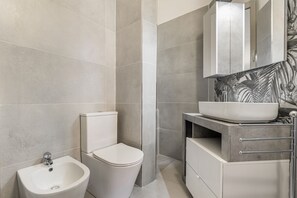 Een douche, een haardroger, een bidet, handdoeken