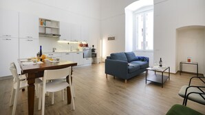 Eine moderne Wohnung mit Essbereich, Küche, Wohnzimmer und einem großen Fenster.