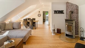 Ein modernes Wohnzimmer mit einer Couch, einem Esstisch und einem Kamin.