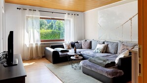 Een moderne woonkamer met een bank, salontafel en televisie.