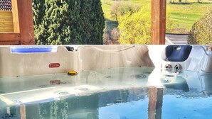 Een jacuzzi met vrij uitzicht op een bergachtig landschap door de houten constructie.