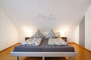 A bedroom with a bed, two bedside tables, and a wall decoration.