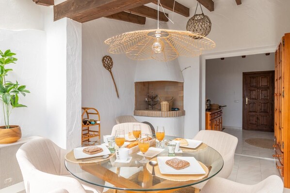 A dining area with a glass table set for breakfast, including plates, glasses, and a basket. - Bahia Sun Moraira - Moraira, Costa Blanca (Moraira)