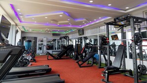 A gym with treadmills, weight machines, and exercise mats. - IKE CITY Hotel (Tema)