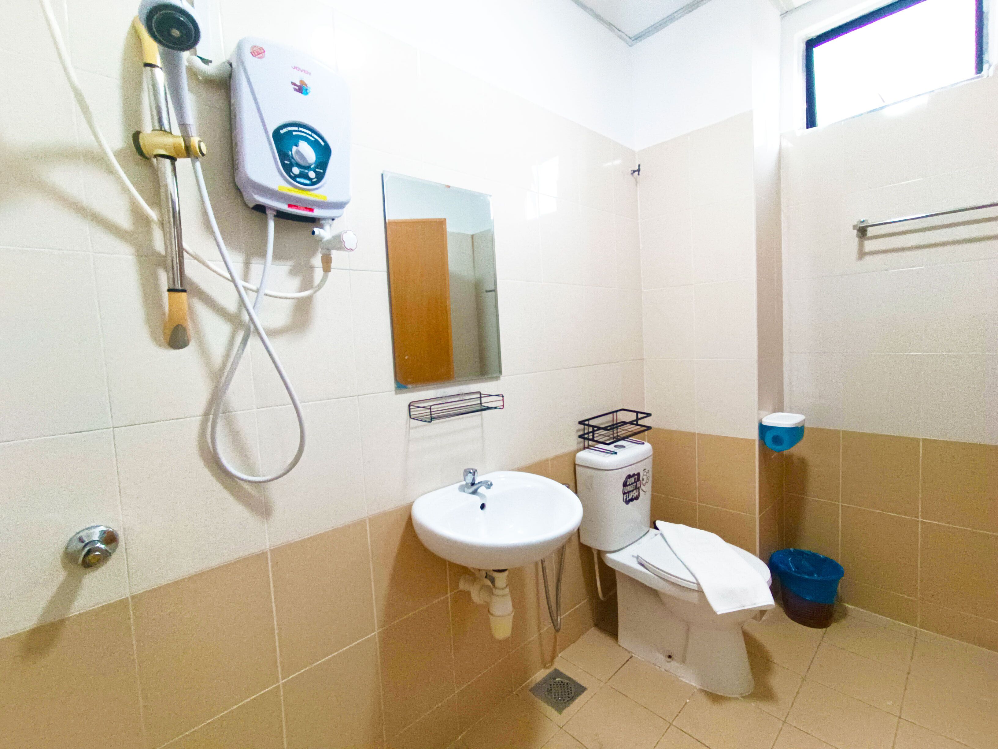 A small bathroom with a sink, toilet, and shower.
