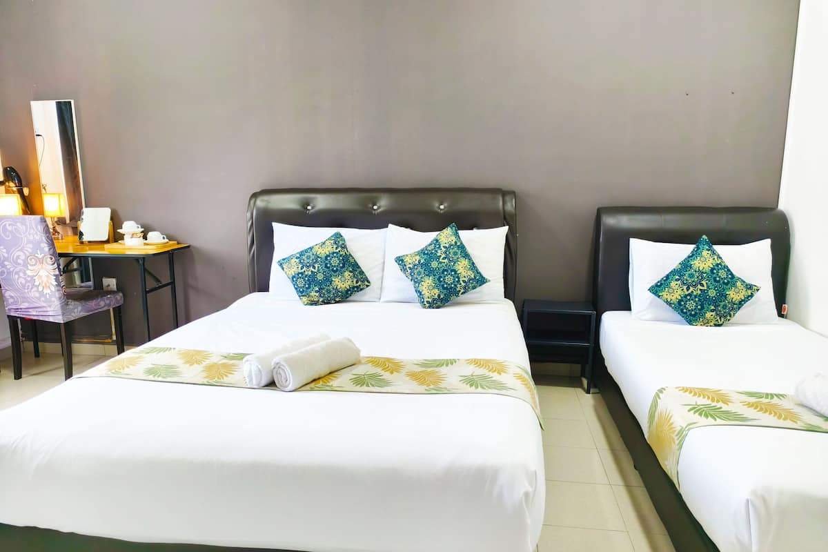 Une chambre d’hôtel avec deux lits, un bureau et une chaise.
