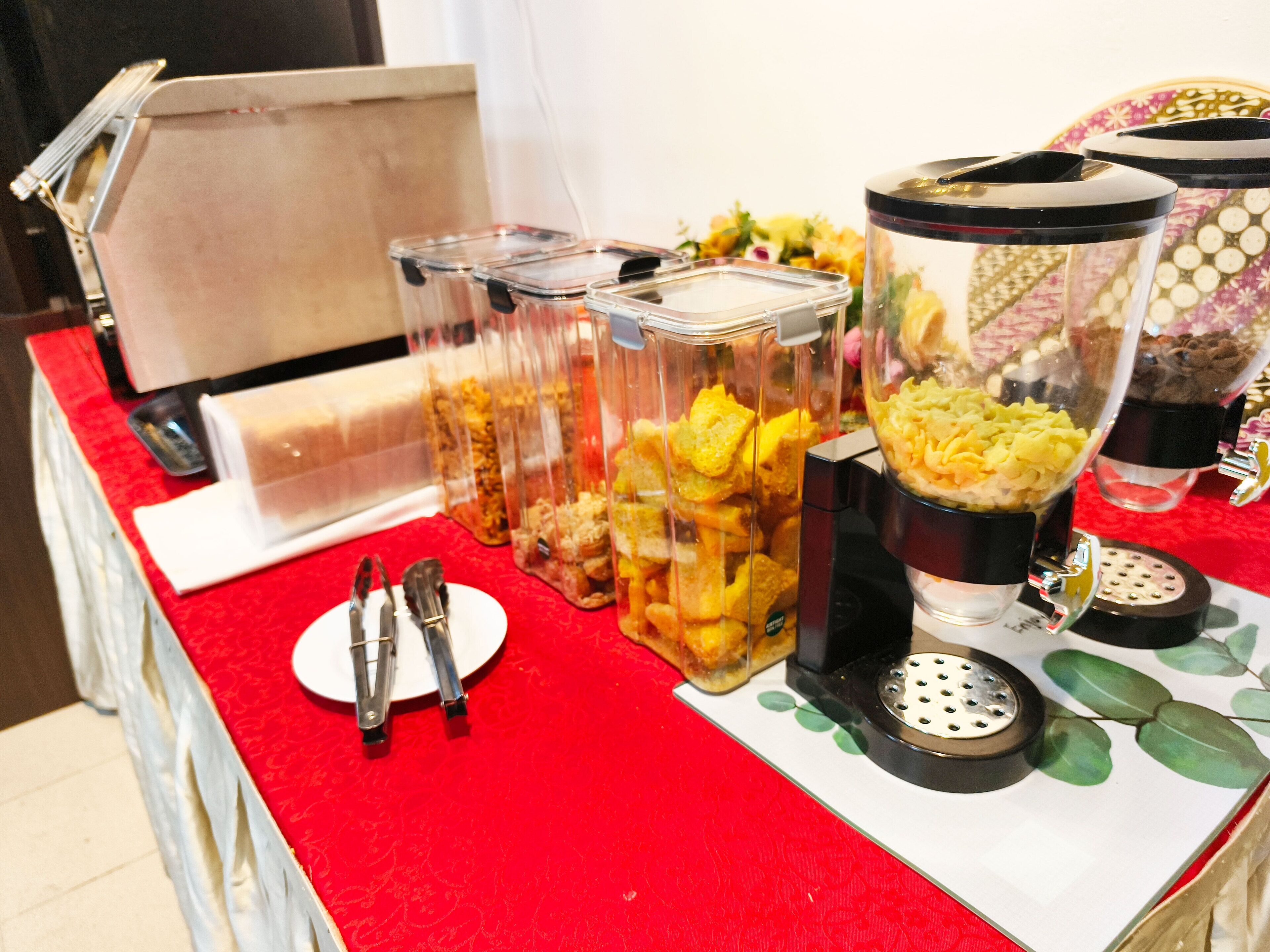 A buffet table with various food containers and utensils.