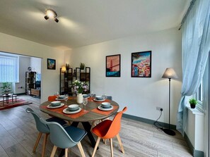 A dining area with a round table, chairs, and a floor lamp. - Lenhurst House – Contractors, Families, Holidays (Cleethorpes)