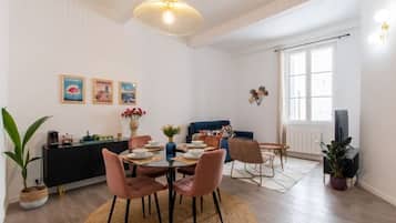 Un espace repas comprenant une table ronde, des chaises et un luminaire suspendu.