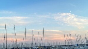 Ein Yachthafen mit zahlreichen Segelbooten unter blauem Himmel.