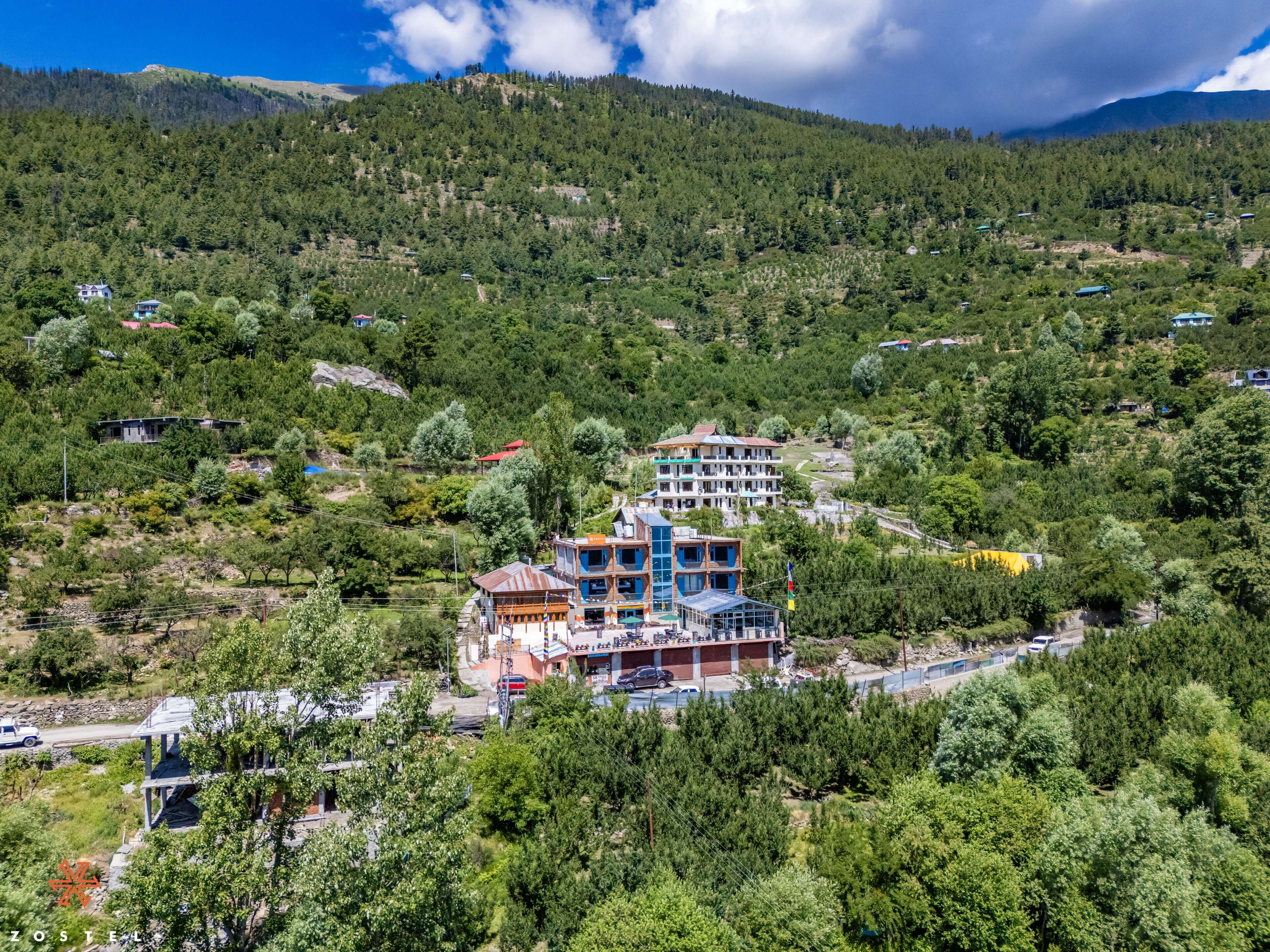 A multi-story hotel with a view of a mountainous landscape.