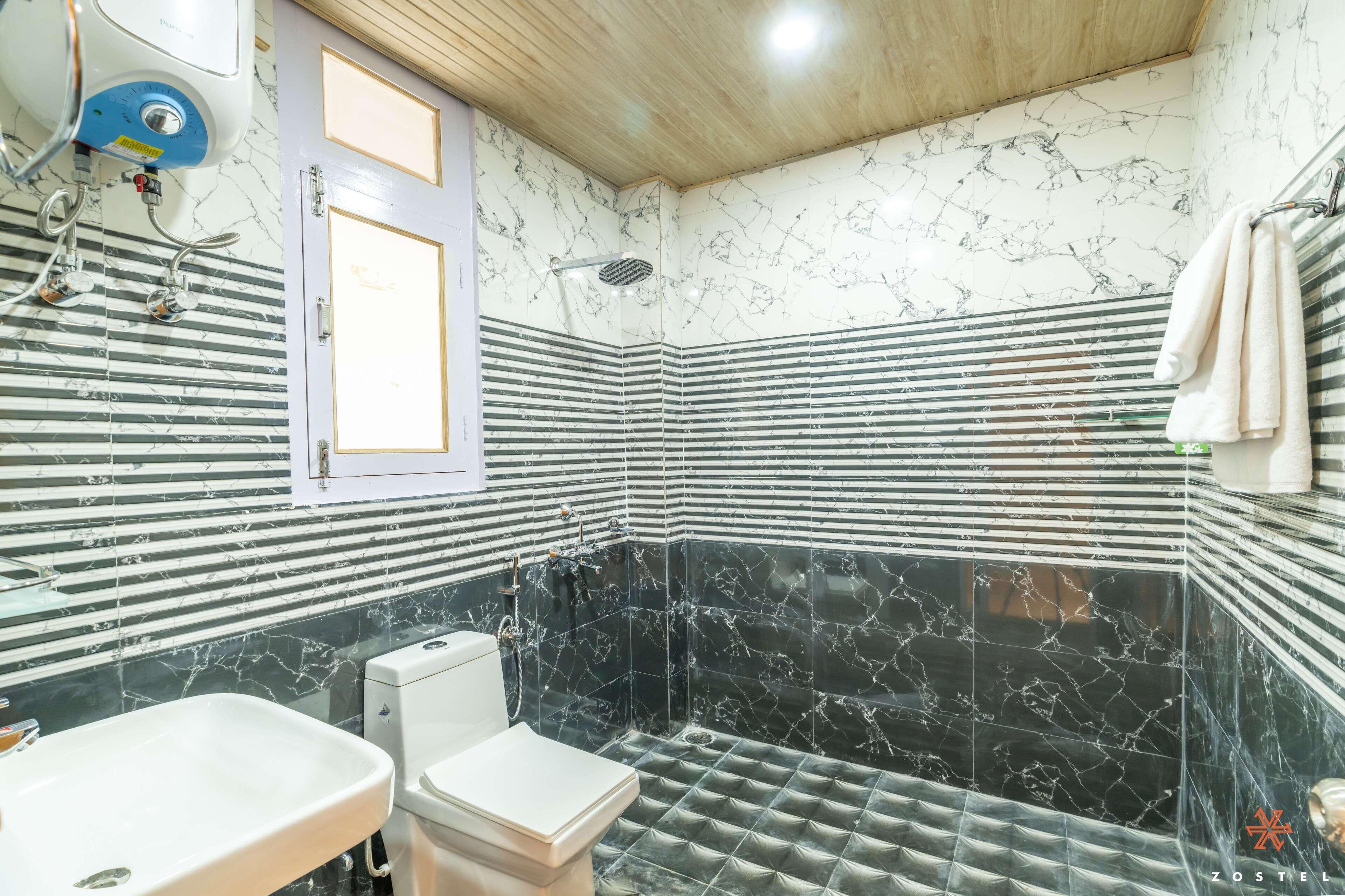 Un baño con inodoro, lavamanos y ducha.