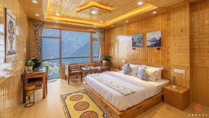 A wooden-paneled room with a bed, desk, and chairs, a large window with a view, and a small balcony. - Zostel Kalpa (Kalpa)