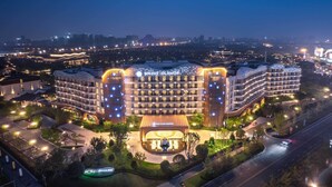 Een hotel met meerdere verdiepingen, met een modern design, een opvallende ingang en een goed verlichte gevel.