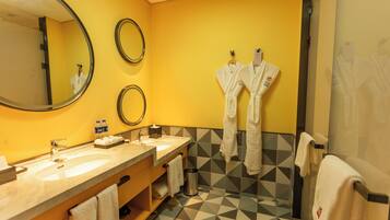 Un baño con dos lavamanos, un espejo y toallas colgadas en la pared.