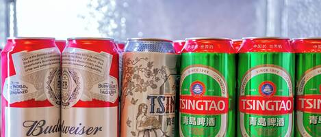 A row of beer cans on a shelf.