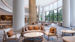 Een ruime lobby met hoge plafonds, grote ramen en moderne inrichting.
