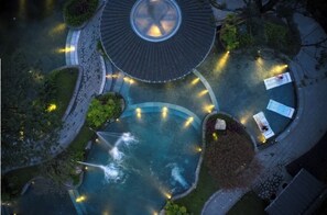 An aerial view of a landscaped area with a central pool, surrounding pathways, and seating areas. - Blossom Attic DuJiangYan (Chengdu)