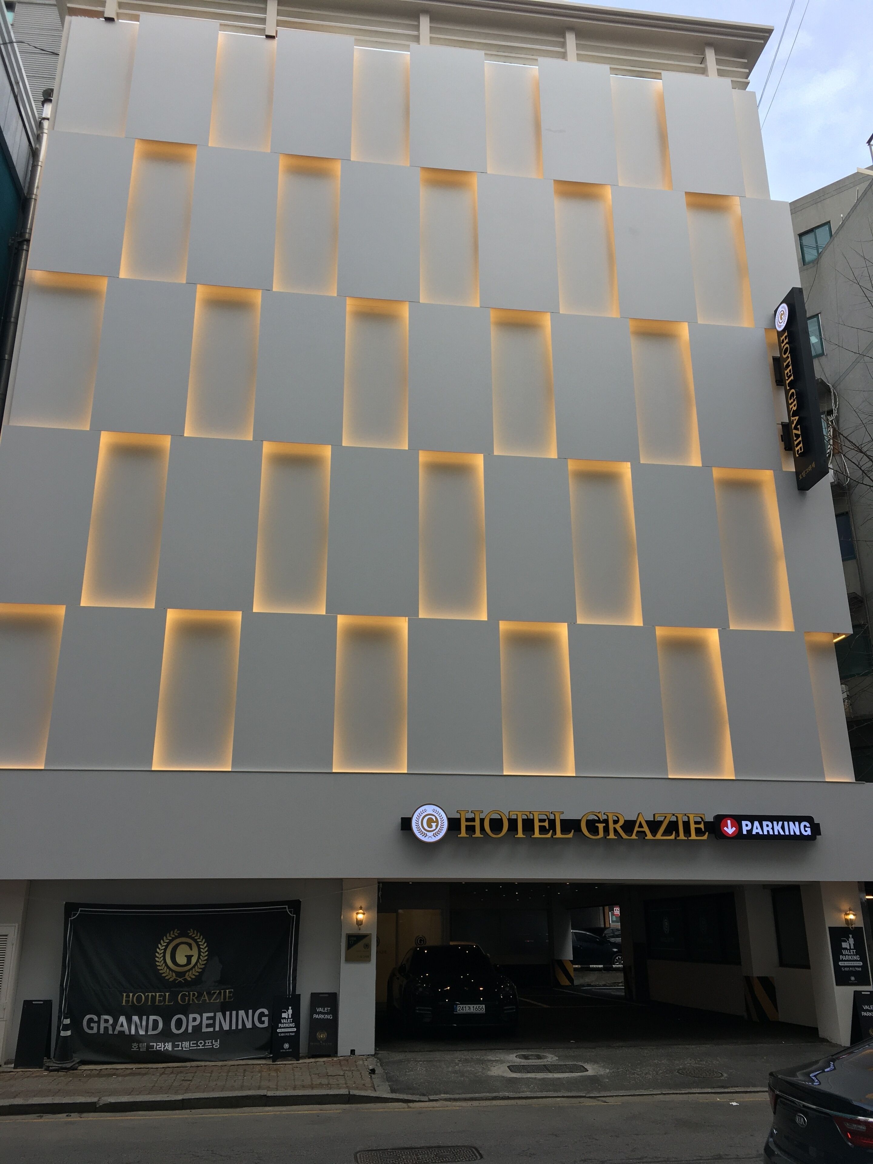 A modern hotel facade with illuminated panels and a sign for Hotel Grazie.
