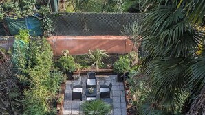 Un jardin sur le toit, agrémenté d’un chemin en pierre, d’un espace détente et de plantes en pot.