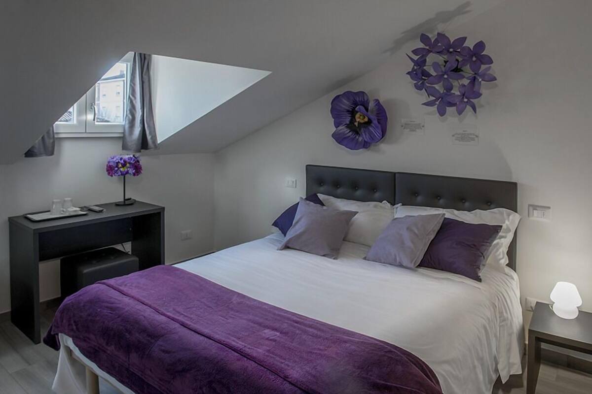 Ein Schlafzimmer mit Bett, Schreibtisch und Fenster.