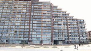 A multi-story residential building with balconies, a central courtyard, and a pedestrian walkway. - Apartment near Port with Scenic Views (Nieuwpoort)