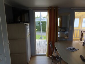Enjoy meals in the compact kitchen with a refrigerator and microwave, and step out to the adjacent patio with a wooden deck.