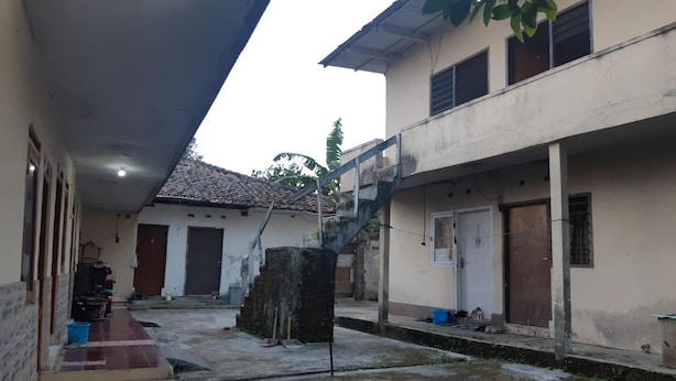 Um pátio com piso de azulejos, escadas e um edifício com telhado telhado.