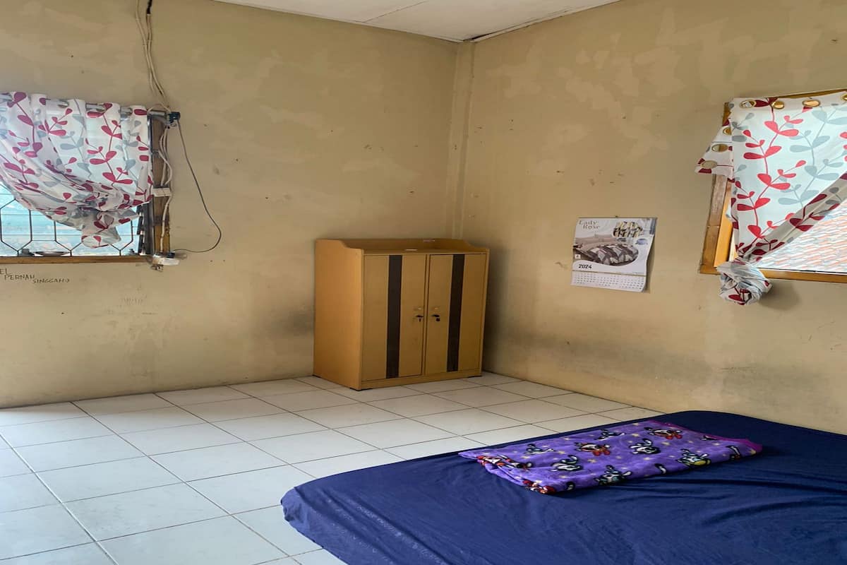 A room with a bed, a wardrobe, and a calendar on the wall.