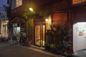 A building with a wooden facade, a visible entrance, and a bicycle parked outside.