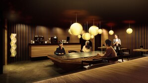 A modern interior with a reception desk, wooden paneling, and pendant lighting.