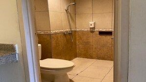 A bathroom with a toilet, a shower, and a hand dryer. - OYO 94106 Kitarooms Property (Curug)