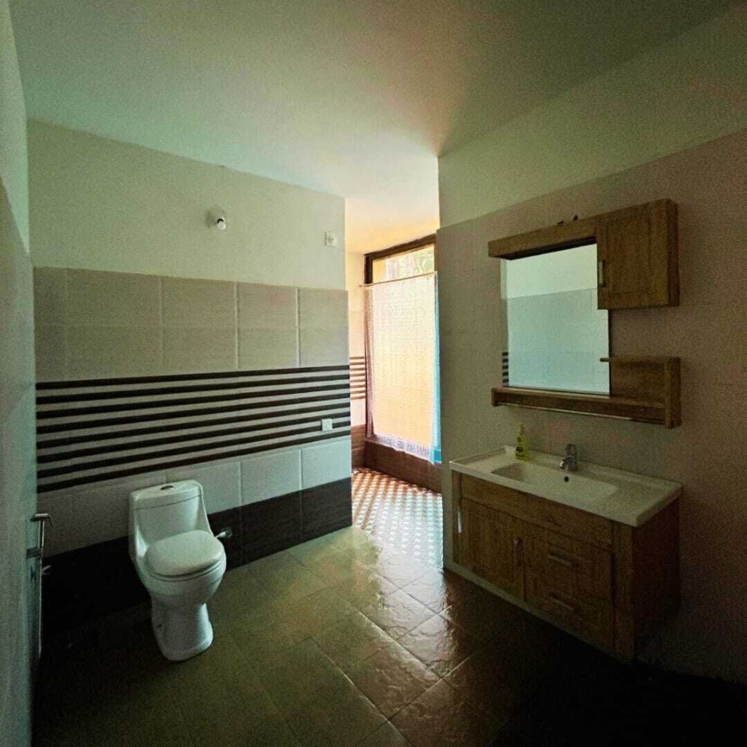 A bathroom with a toilet, sink, and mirror.