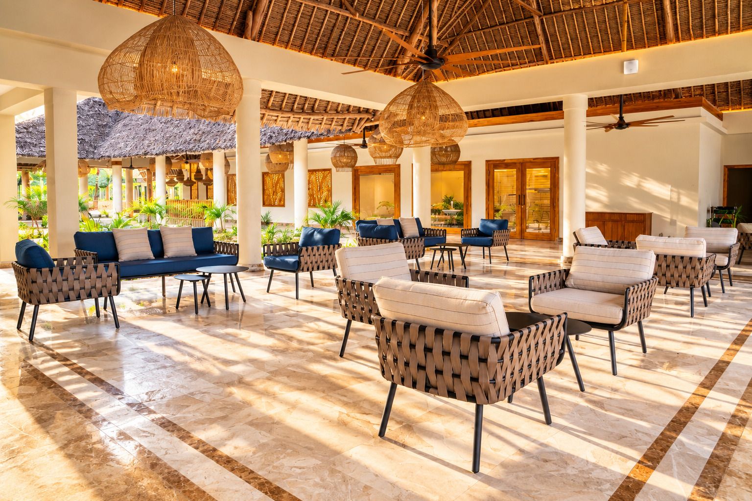 A spacious indoor area with a high ceiling, wicker furniture, and a tiled floor.