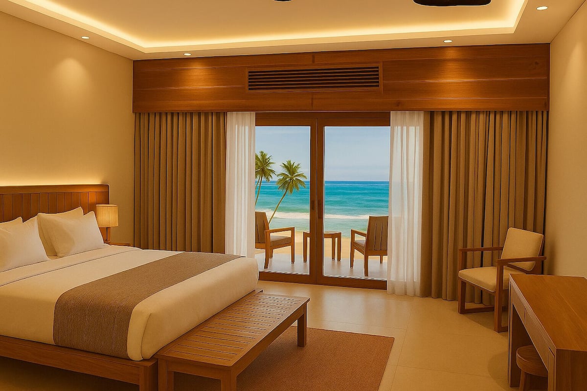 A hotel room with a large bed, a desk, and a view of the beach.