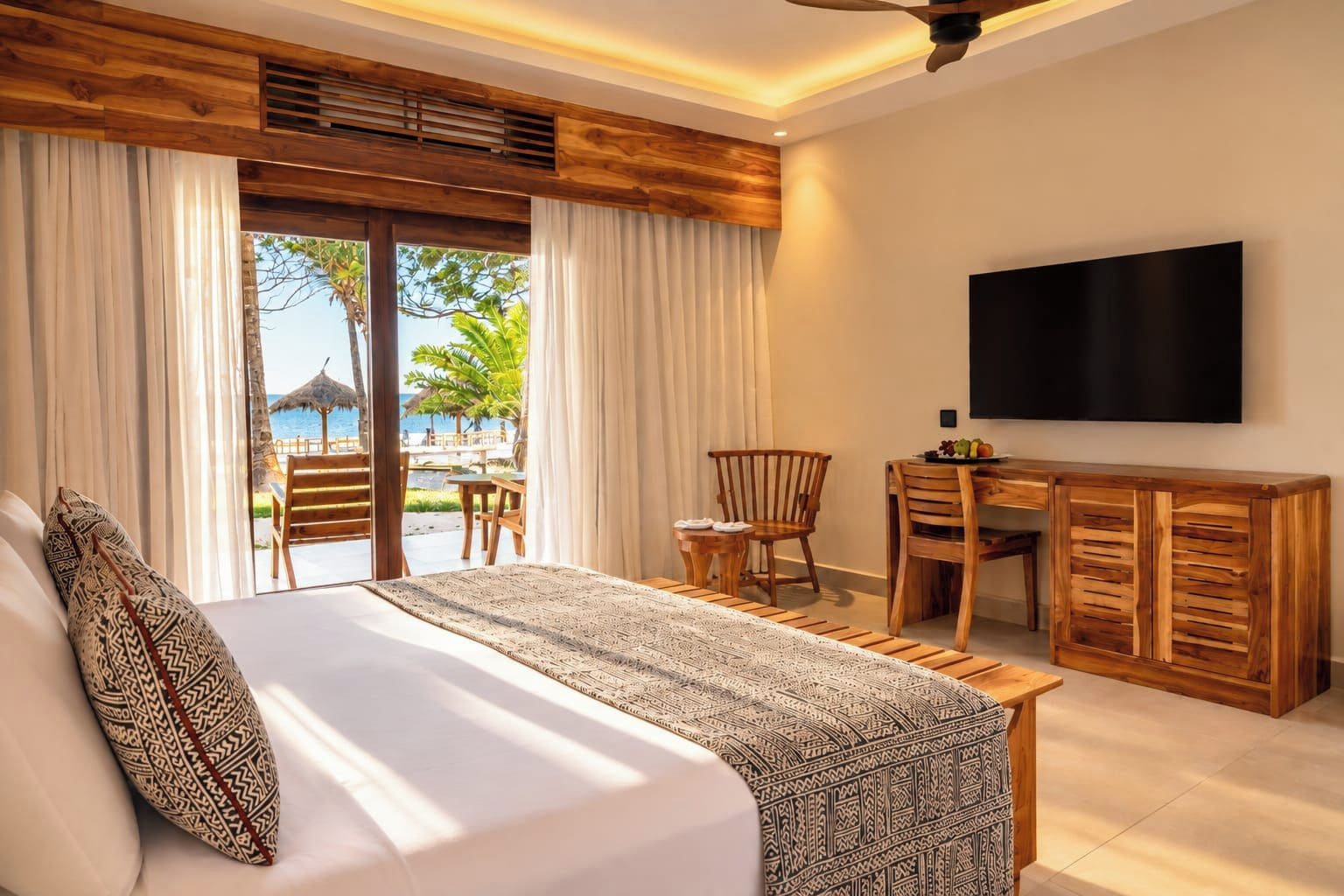 A hotel room with a bed, a desk, a chair, and a TV.