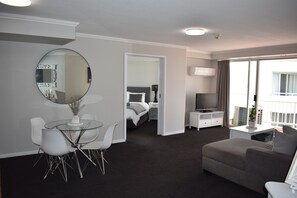 Relax in a stylish space with a comfortable sofa, glass dining table, and a large window offering a view.