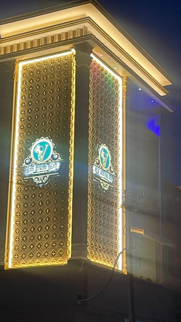 A building with two illuminated vertical panels featuring decorative emblems and text.