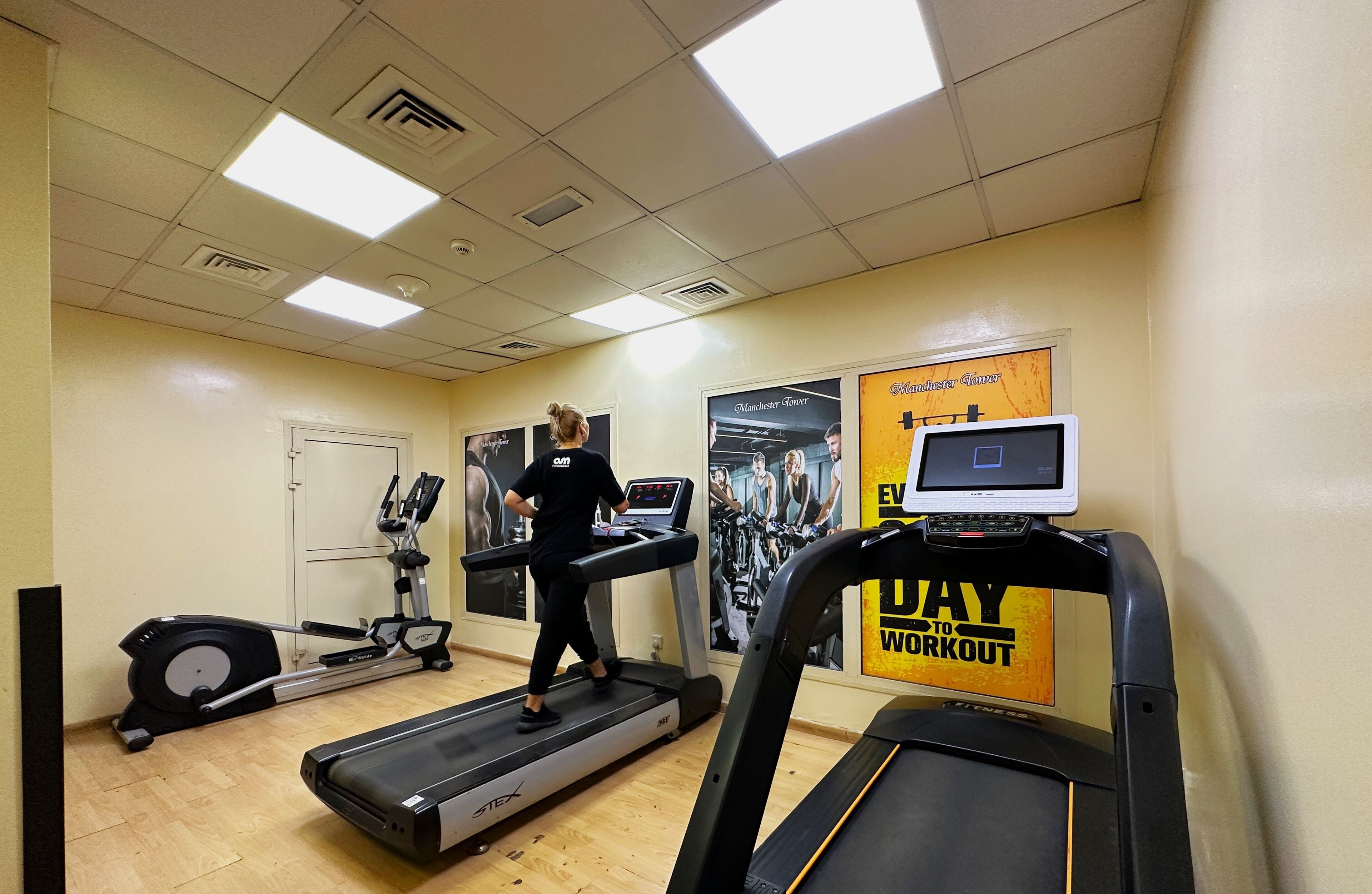 Una palestra con tapis roulant, biciclette fisse e attrezzature per esercizi.