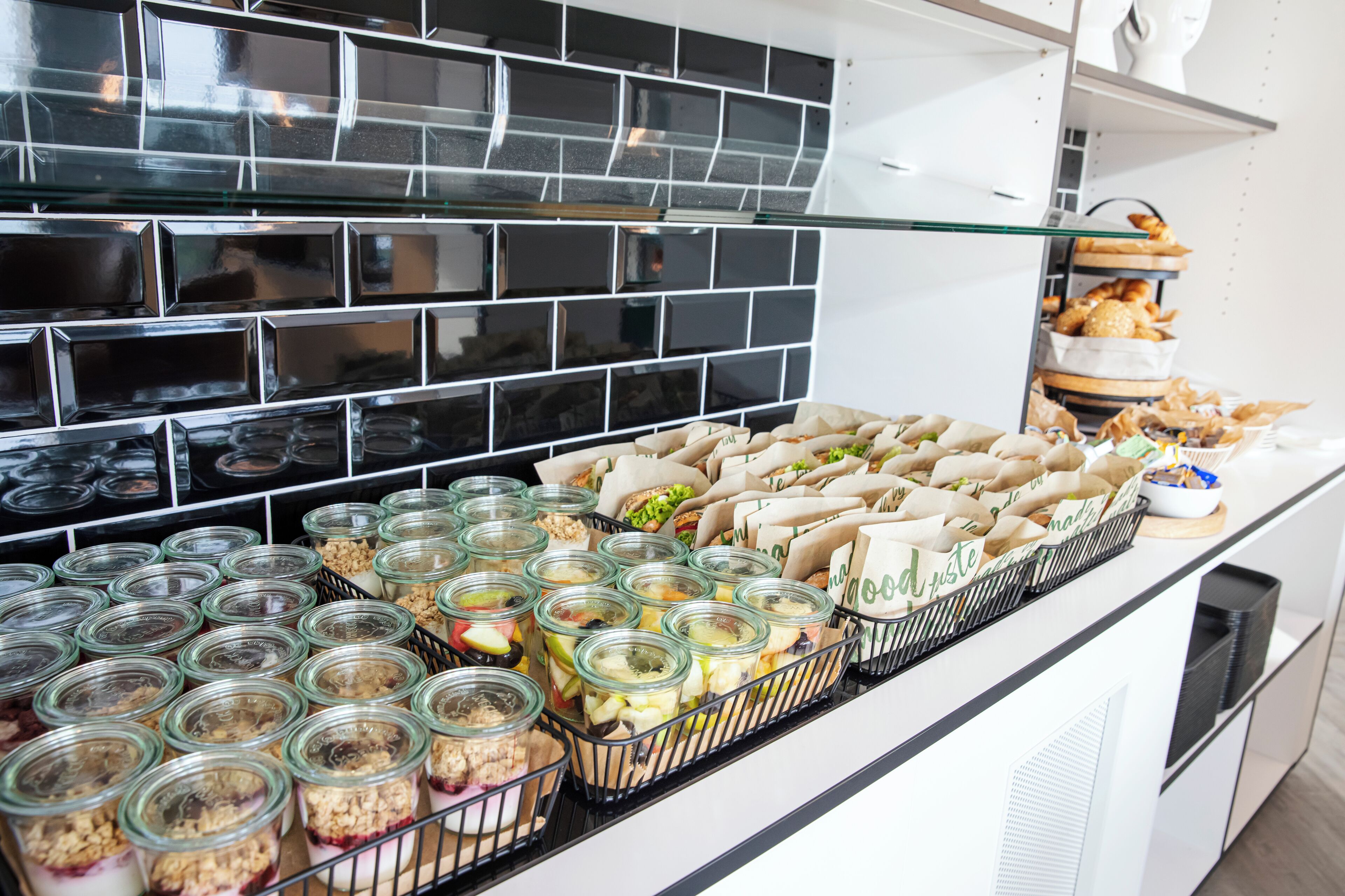 A buffet with various food items, including jars of food and trays of sandwiches.